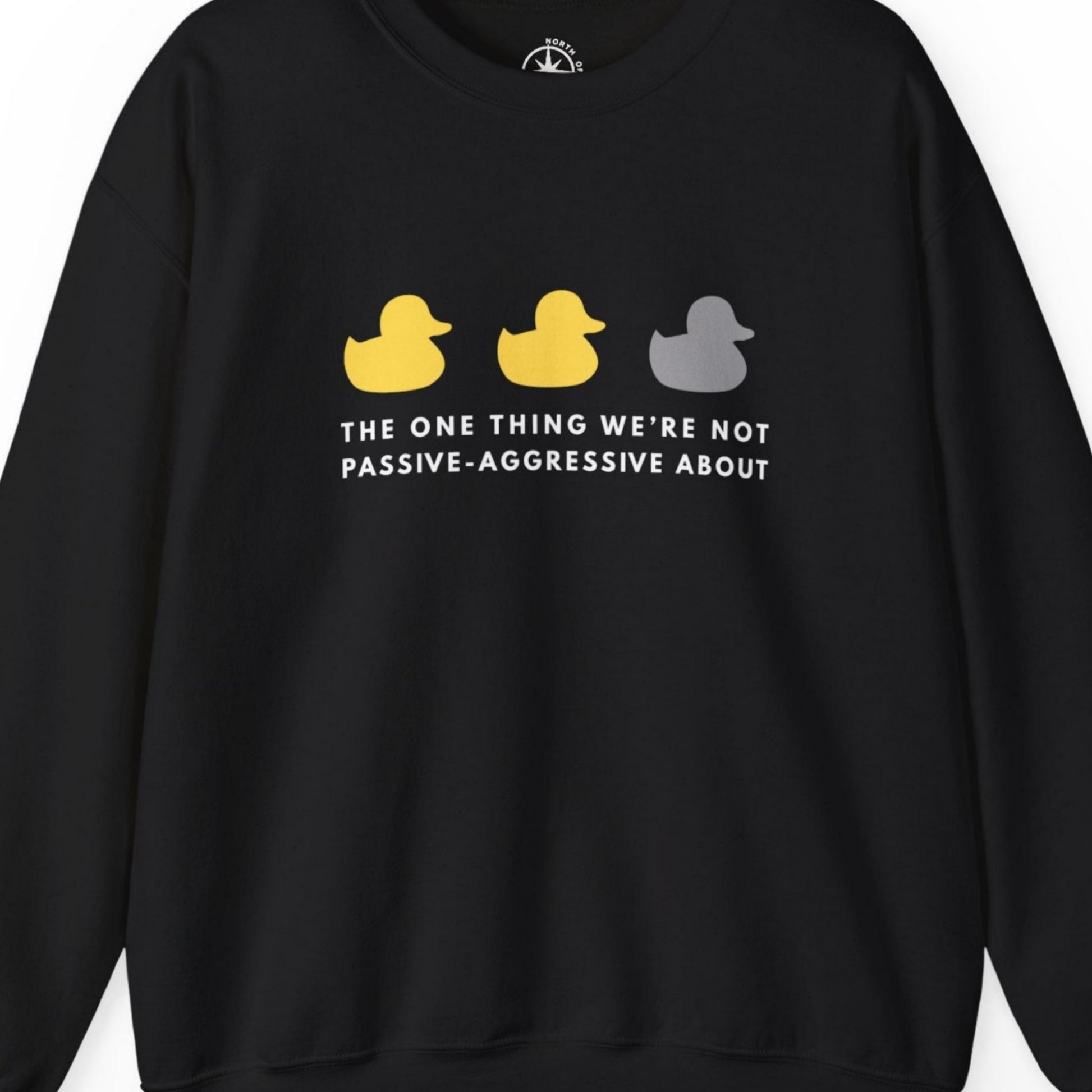 Black sweatshirt with three ducks and text reads, The one thing we're not passive-aggressive about. 